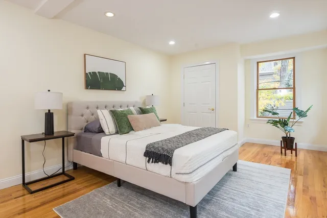 a spacious bedroom with a bed and a lamp