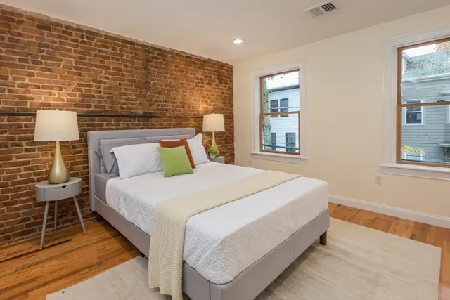 a large bed sitting in a bedroom next to a window