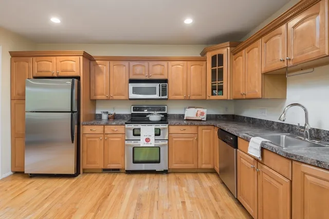 a kitchen with stainless steel appliances granite countertop a refrigerator sink and microwave