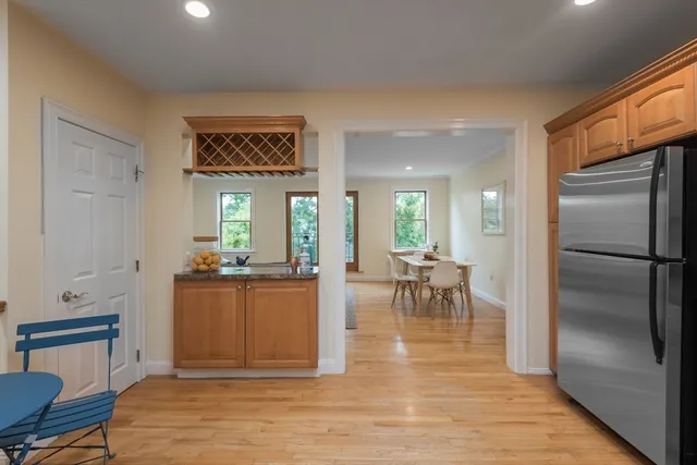 a living room with furniture a large window and stainless steel appliances