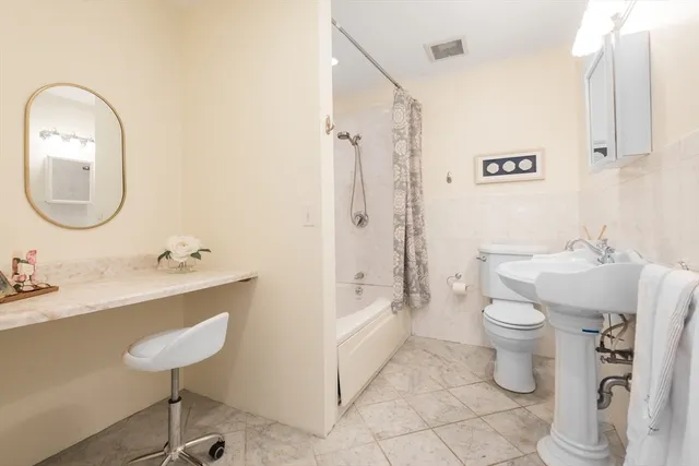 a bathroom with a sink a toilet and a mirror