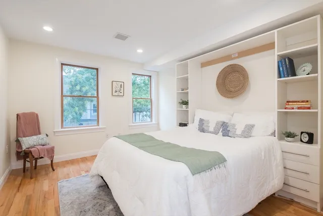 a bedroom with a bed and chair with window