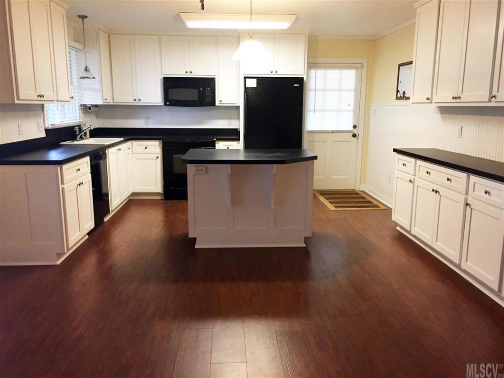 2187 Startown Road Newton, NC 28658 - Photo 13 of 21 a kitchen with stainless steel appliances a stove top oven a sink a refrigerator white cabinets and wooden floor