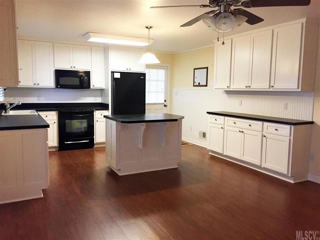2187 Startown Road Newton, NC 28658 - Photo 16 of 21 a kitchen with granite countertop a stove top oven a sink a counter space and cabinets