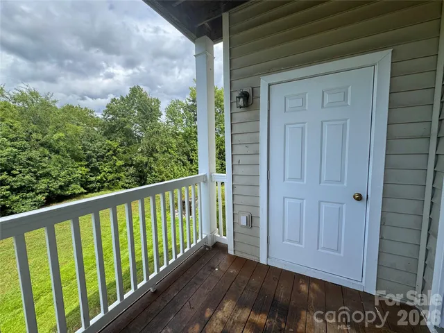 a view of a balcony with wooden floor and fence