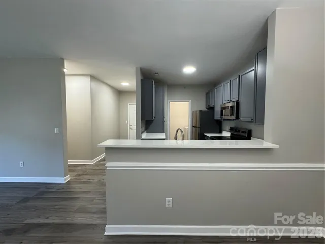 a view of kitchen with stainless steel appliances granite countertop refrigerator sink and cabinets