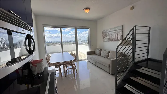 a living room with furniture a flat screen tv and a large window