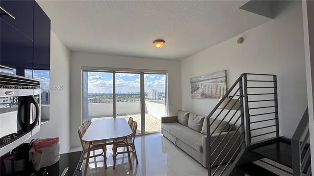 a living room with furniture a flat screen tv and a window