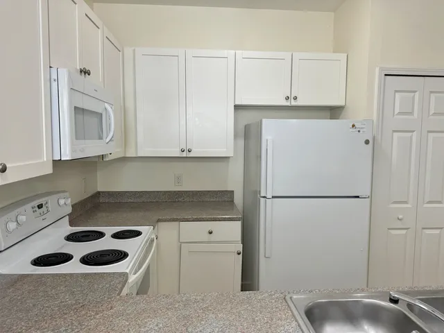 a kitchen with a refrigerator sink and cabinets