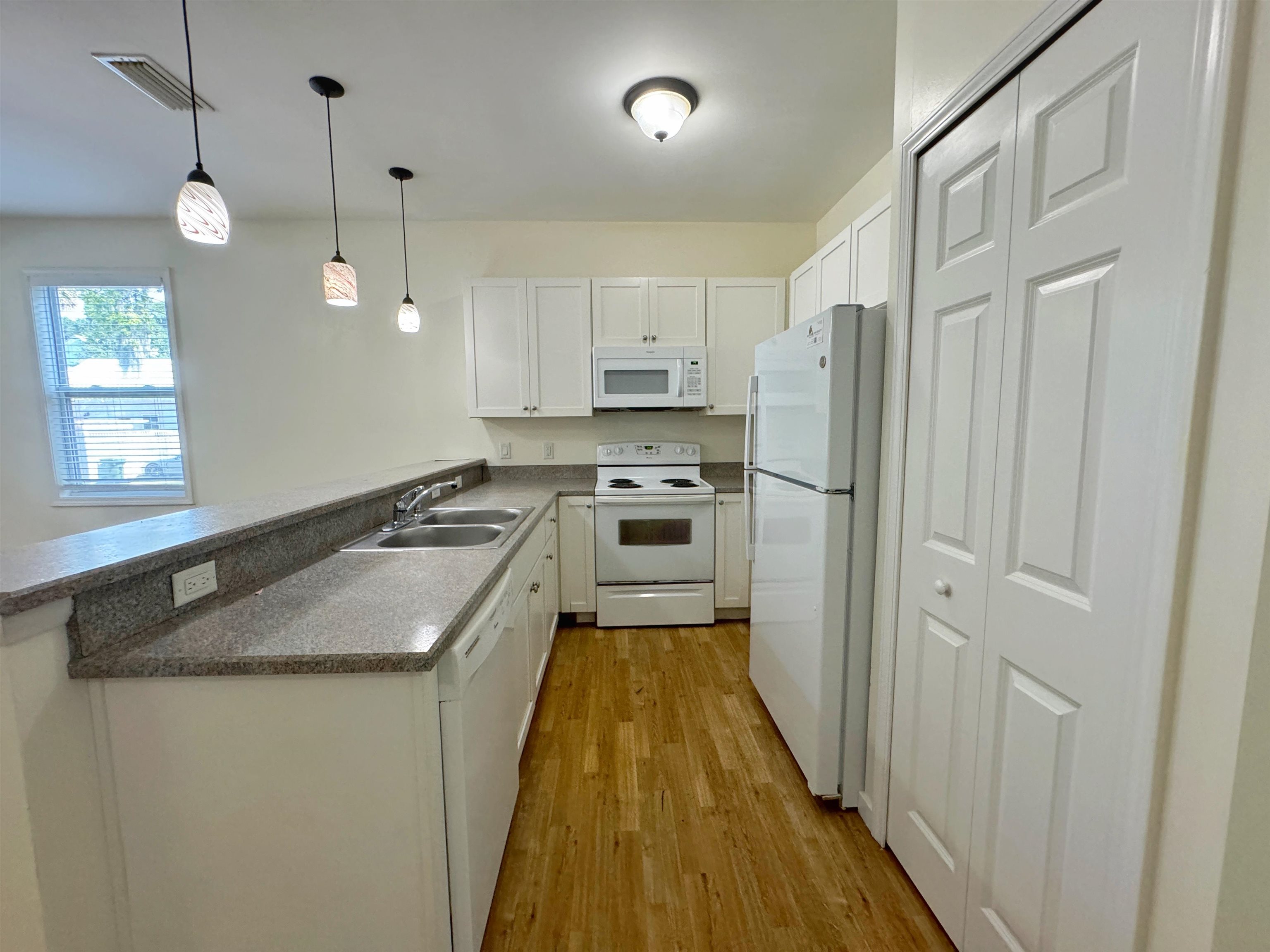 38 Weeden Street, Unit A St. Augustine, FL 32084 - Photo 12 of 29 a kitchen with kitchen island a counter top space a sink a refrigerator and cabinets