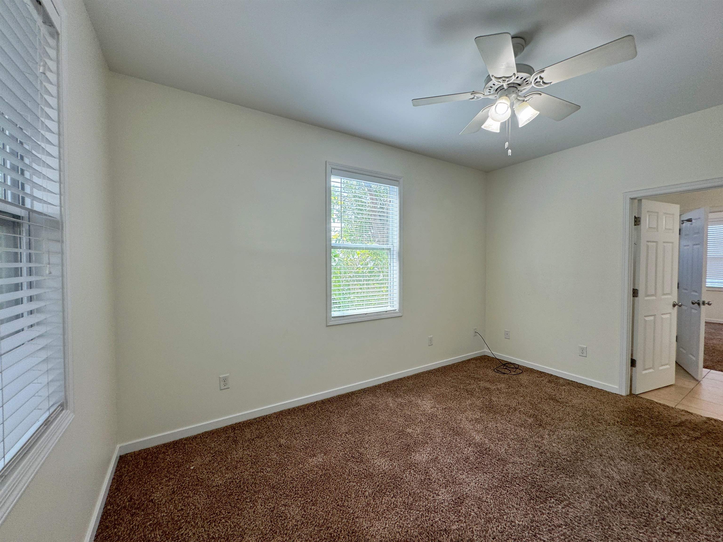 38 Weeden Street, Unit A St. Augustine, FL 32084 - Photo 16 of 29 en empty room with windows and chandelier fan