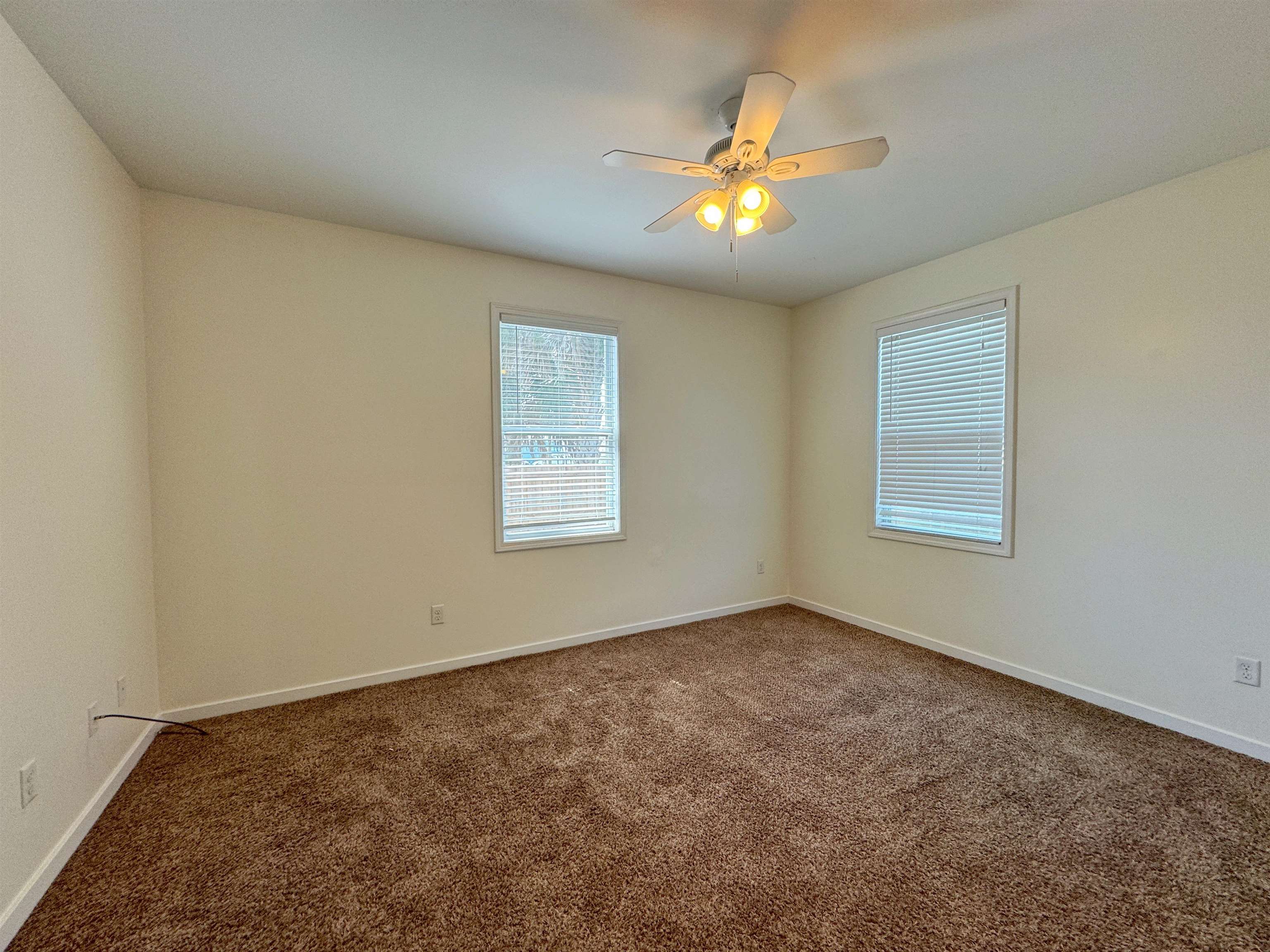 38 Weeden Street, Unit A St. Augustine, FL 32084 - Photo 29 of 29 an empty room with a chandelier fan and windows
