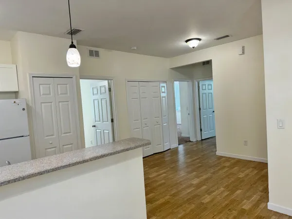 a view of a hallway with wooden floor and staircase