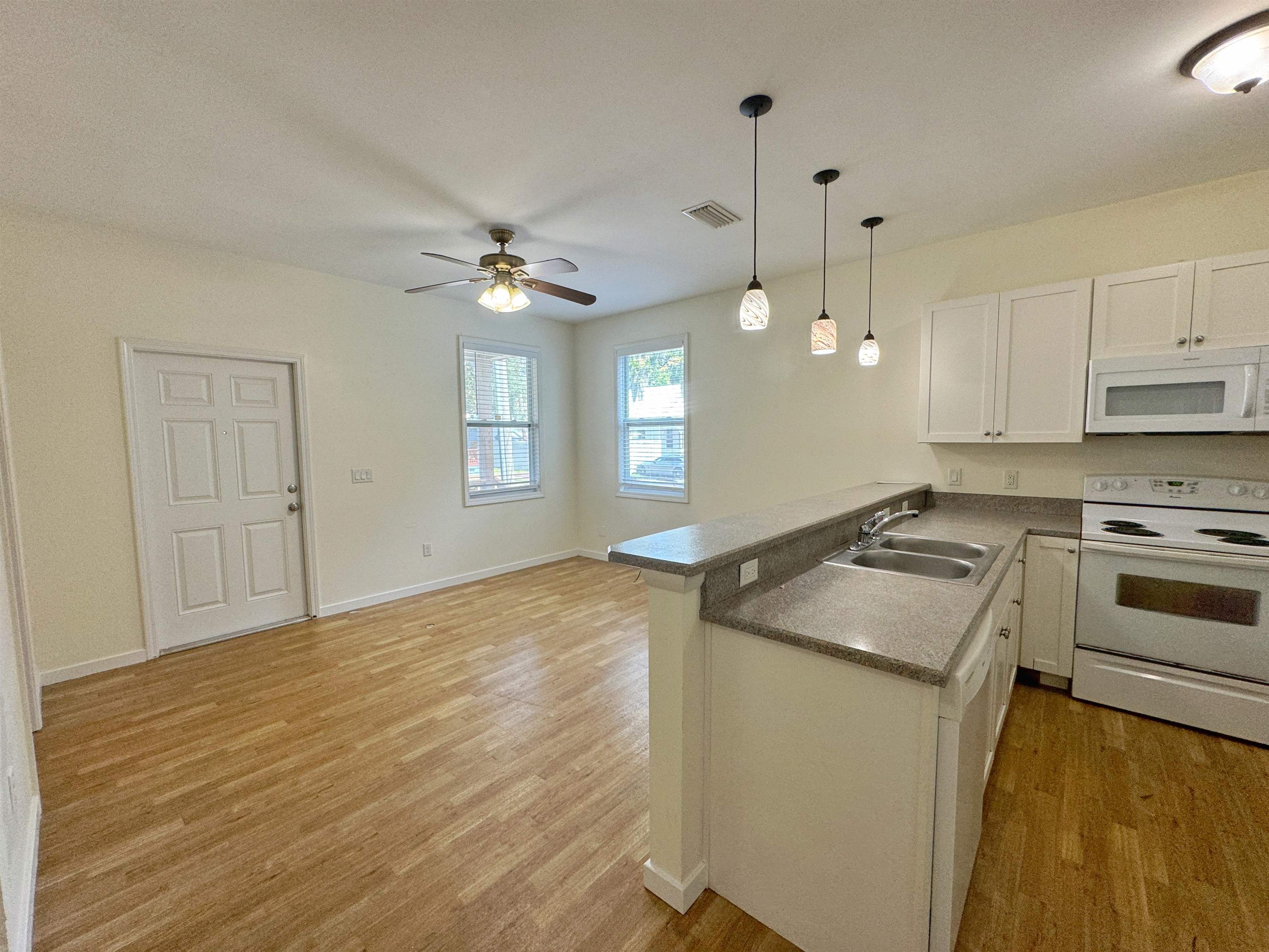 38 Weeden Street, Unit A St. Augustine, FL 32084 - Photo 10 of 29 a kitchen with granite countertop a sink stainless steel appliances and white cabinets