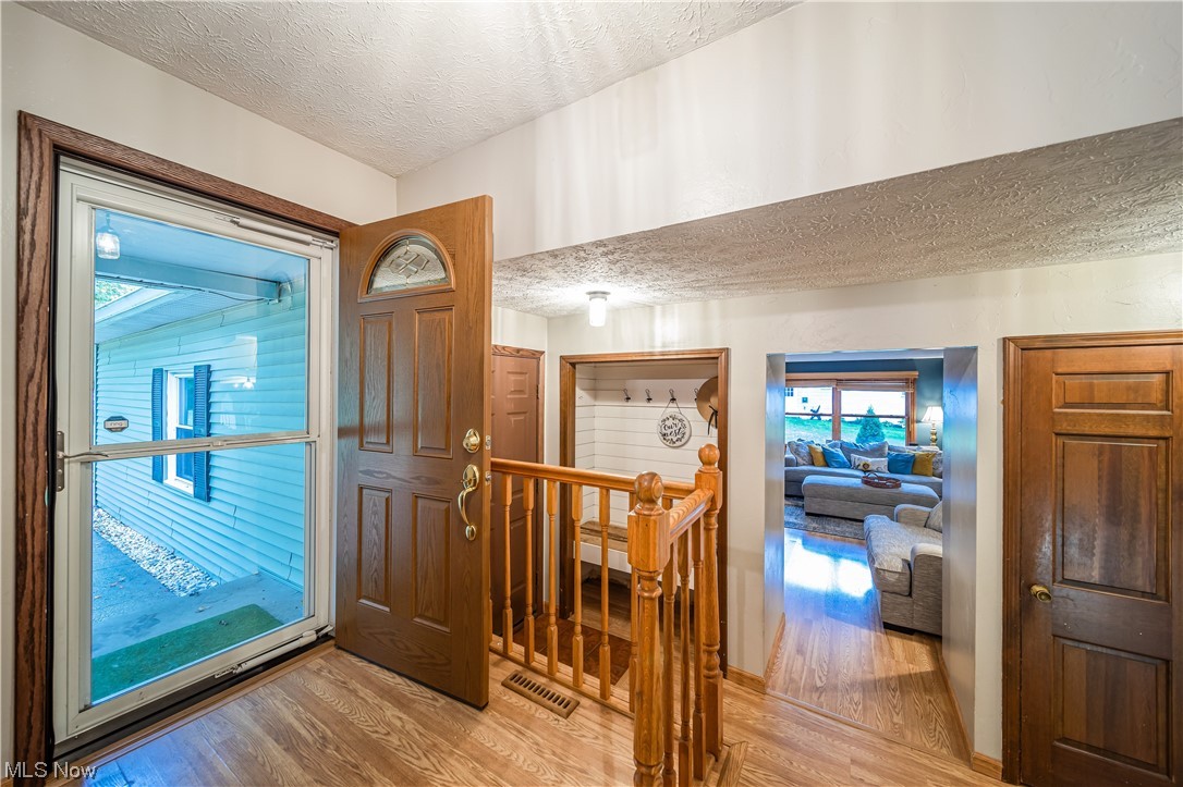 7585 Middle Ridge Road Madison, OH 44057 - Photo 13 of 35 Hardwood floored foyer entrance featuring a textured ceiling