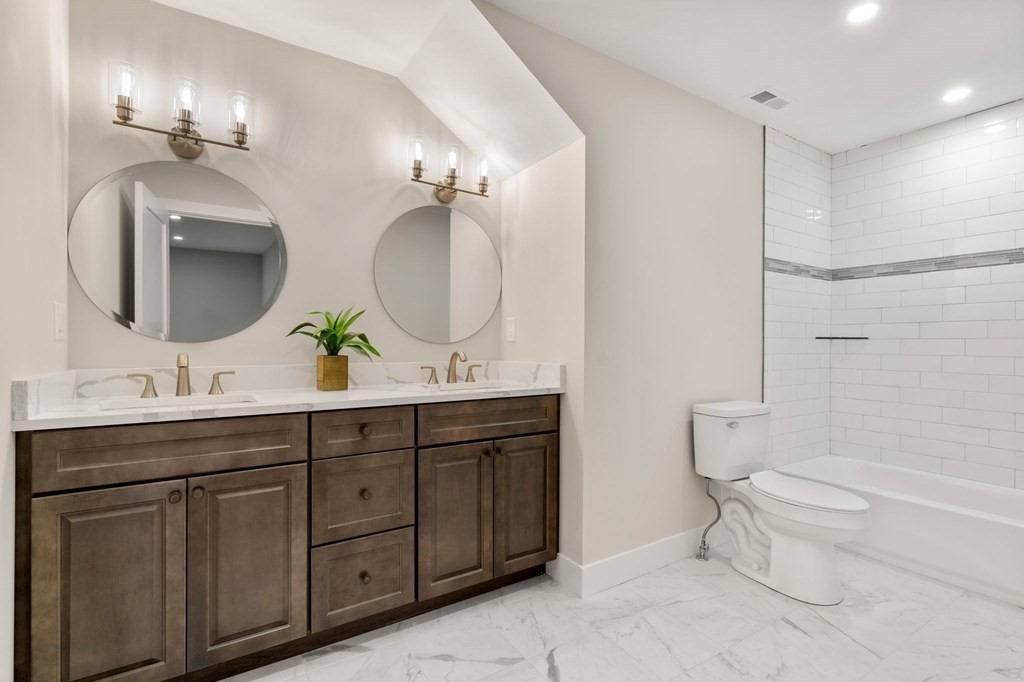 4 Emmeline Path, Unit 4 Wayland, MA 01778 - Photo 10 of 14 a bathroom with a toilet a double vanity sink and a mirror