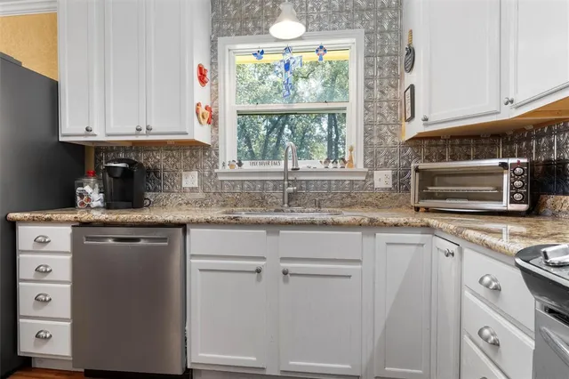 a kitchen with granite countertop white cabinets and white appliances