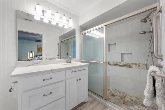a bathroom with a double vanity sink mirror and shower