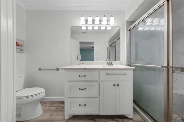 a bathroom with a toilet a sink a mirror and a window