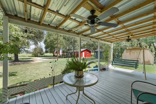 a view of a porch with furniture and a backyard