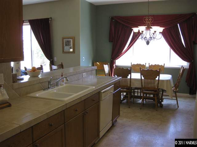 1610 Caliterra Way Reno, NV 89521 - Photo 4 of 13 a bathroom with a granite countertop sink and a large mirror