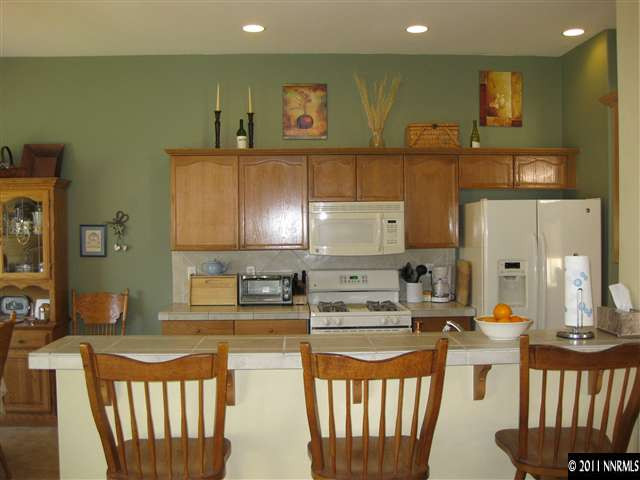 1610 Caliterra Way Reno, NV 89521 - Photo 6 of 13 a kitchen with stainless steel appliances granite countertop a sink a stove a refrigerator a counter top space and cabinets