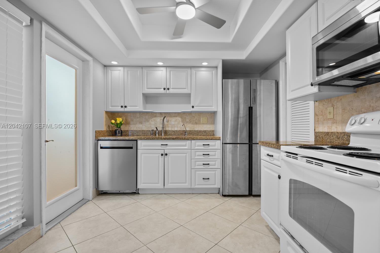 3213 Colony Club Road, Unit 3E Pompano Beach, FL 33062 - Photo 16 of 31 a kitchen with white cabinets and appliances