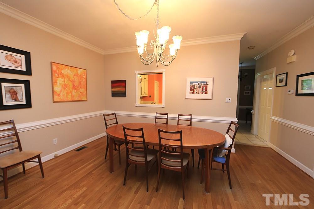 608 Weathergreen Drive Raleigh, NC 27615 - Photo 13 of 25 a view of a dining room with furniture wooden floor and a chandelier