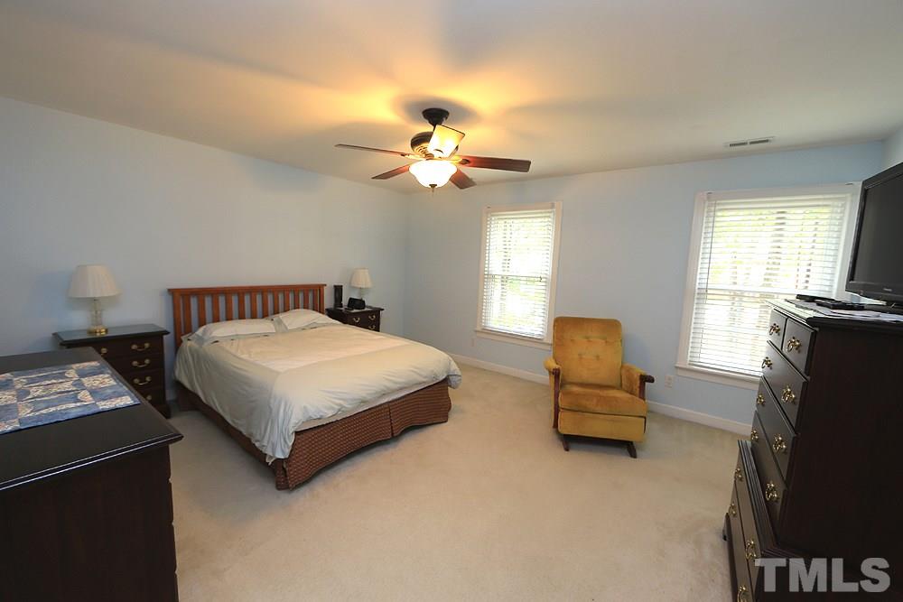 608 Weathergreen Drive Raleigh, NC 27615 - Photo 14 of 25 a bedroom with a bed flat screen tv and window