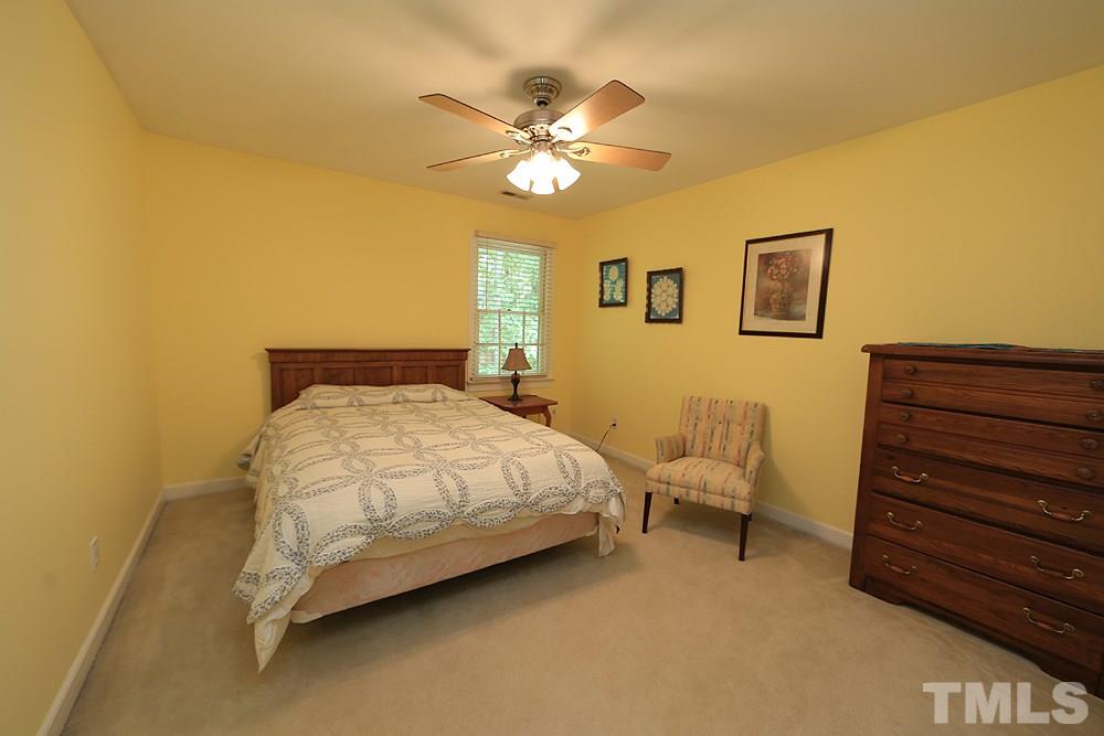 608 Weathergreen Drive Raleigh, NC 27615 - Photo 18 of 25 a bedroom with a bed and a chandelier