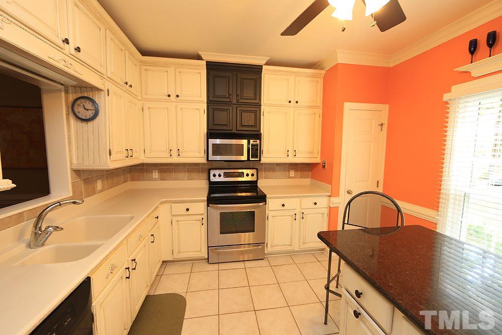 608 Weathergreen Drive Raleigh, NC 27615 - Photo 5 of 25 a kitchen with a sink a stove and cabinets