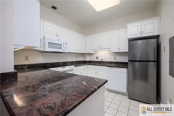a kitchen with stainless steel appliances granite countertop a refrigerator sink and cabinets