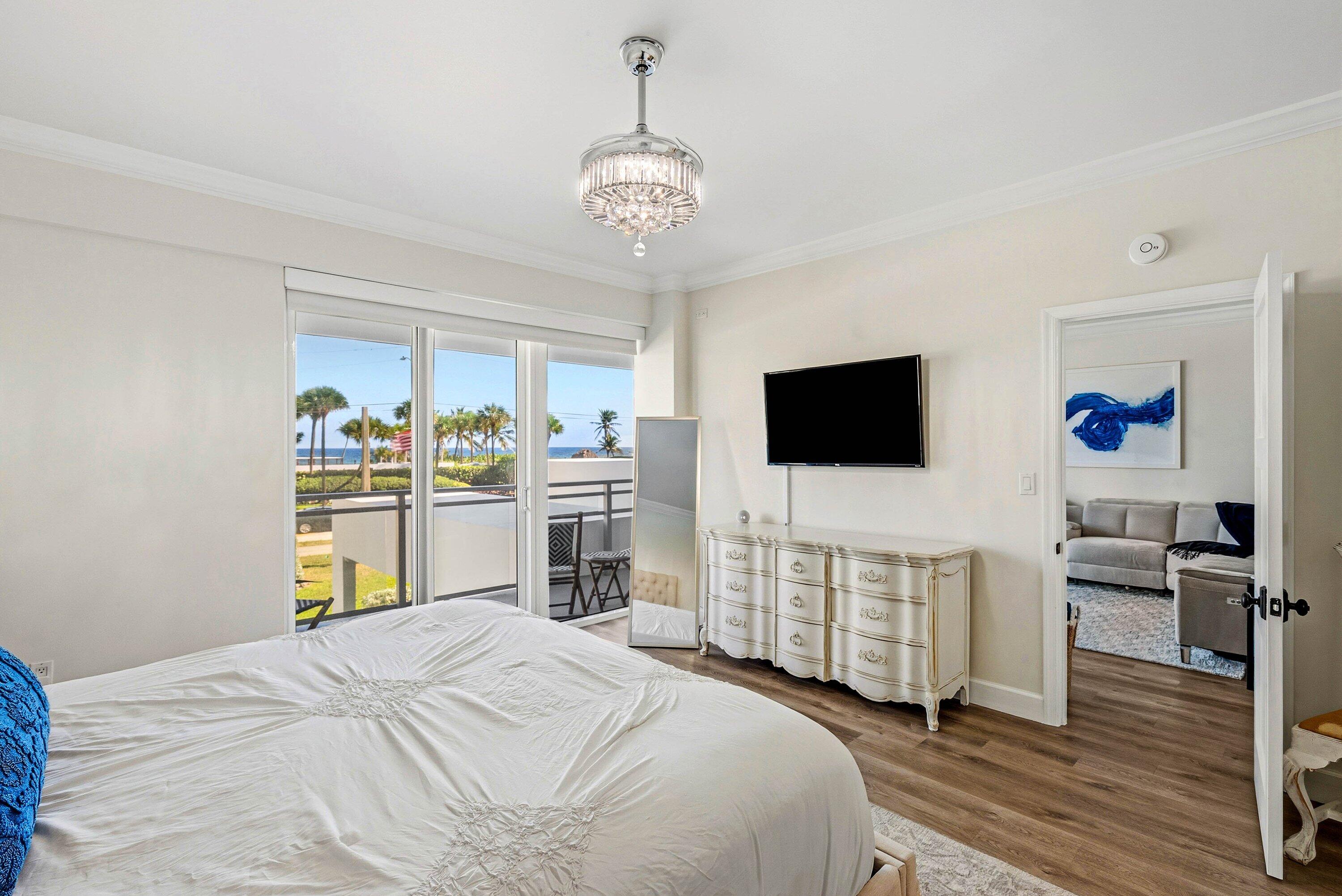 3051 South Ocean Boulevard, Unit 2050 Boca Raton, FL 33432 - Photo 15 of 32 a bedroom with a bed and a flat screen tv