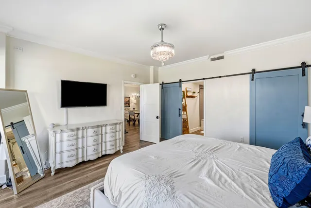 a bedroom with bed tv and flat screen tv