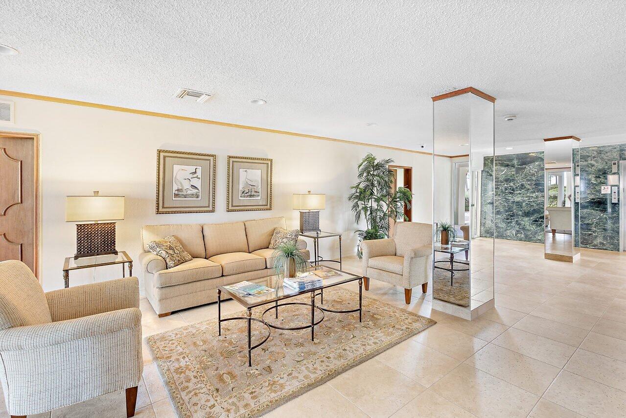 3051 South Ocean Boulevard, Unit 2050 Boca Raton, FL 33432 - Photo 30 of 32 a living room with furniture and a lamp