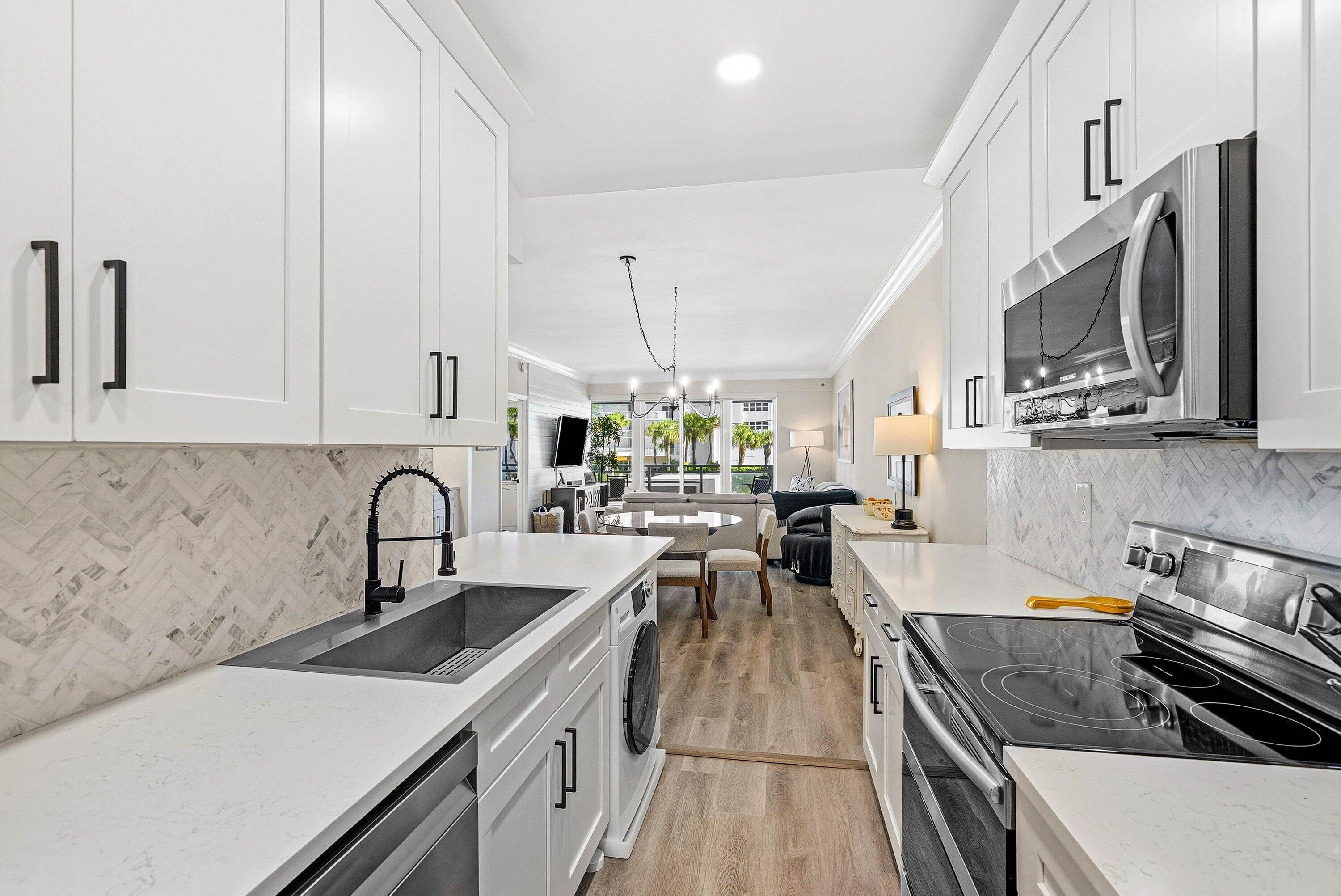 3051 South Ocean Boulevard, Unit 2050 Boca Raton, FL 33432 - Photo 8 of 32 a kitchen with stainless steel appliances a sink a stove top oven a counter space and cabinets