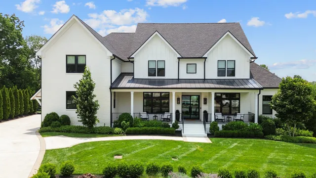 a front view of a house with a yard and potted plants