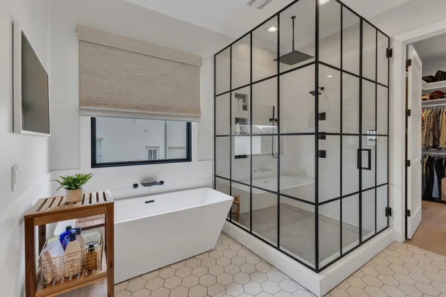 a bedroom with bed and a flat tv screen on dresser