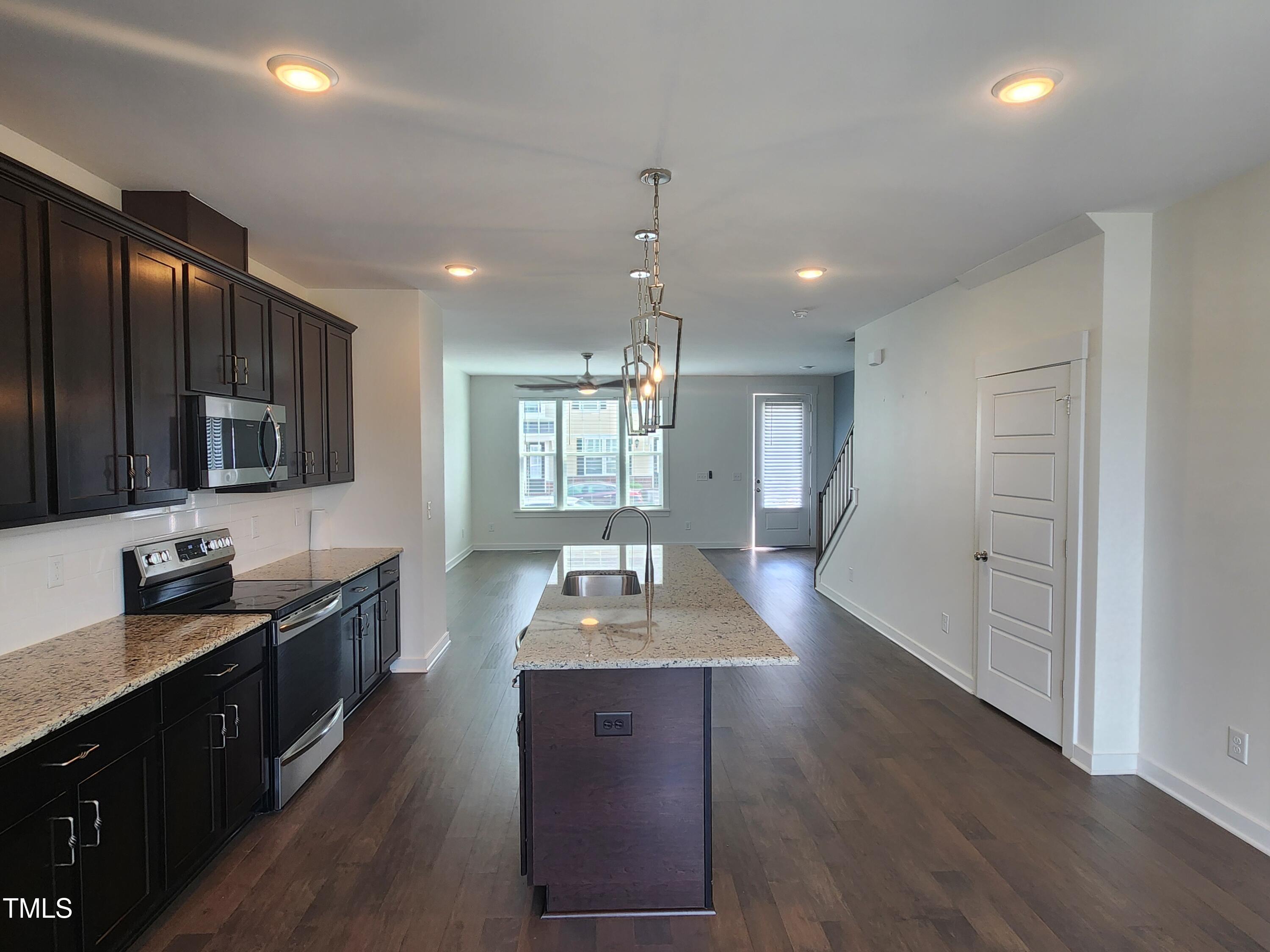 433 Rally Point Place Wake Forest, NC 27587 - Photo 4 of 15 a kitchen with granite countertop wooden cabinets a sink dishwasher and a stove with wooden floor