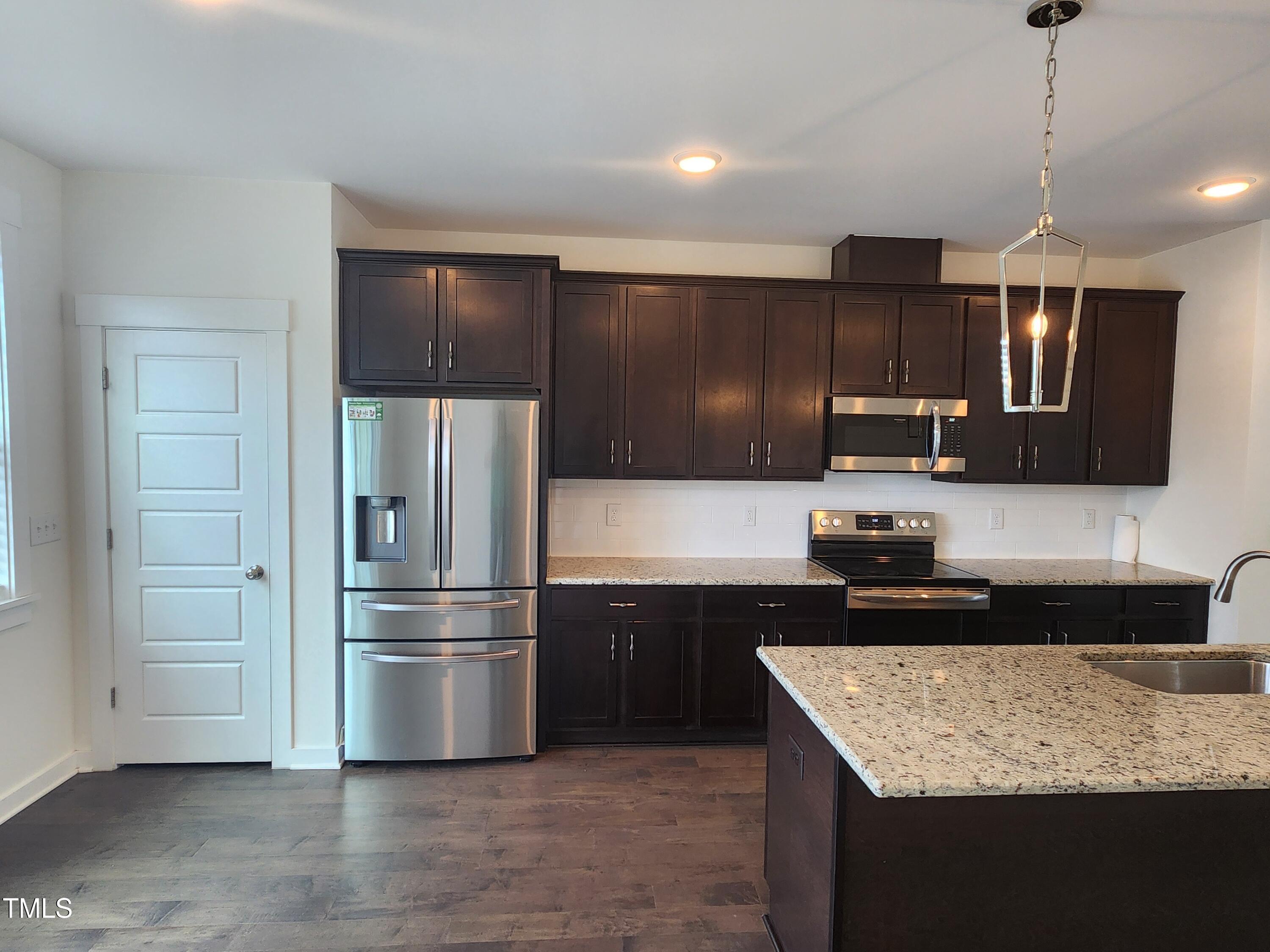 433 Rally Point Place Wake Forest, NC 27587 - Photo 5 of 15 a kitchen with kitchen island granite countertop stainless steel appliances and sink