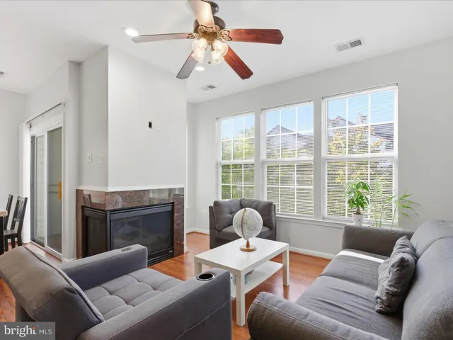 a living room with furniture a large window and a fireplace