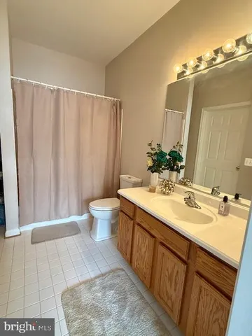 a spacious bathroom with a double vanity sink toilet and a mirror