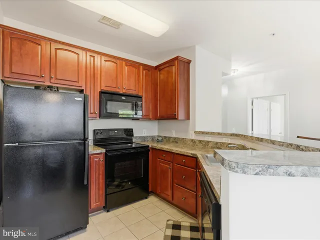 a kitchen with stainless steel appliances granite countertop a refrigerator a stove a sink and a microwave