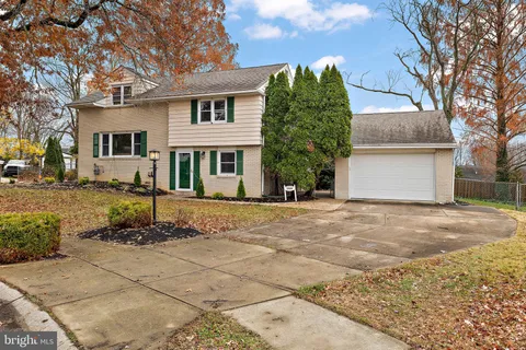 a front view of a house with a yard and potted plants