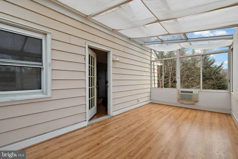 a view of a porch with wooden floor and a window