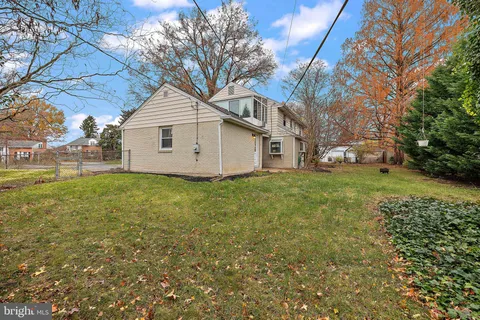 a white house that has a tree in front of it