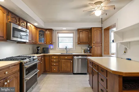 a kitchen with stainless steel appliances granite countertop a sink a stove top oven a counter space and cabinets
