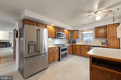 a kitchen with granite countertop stainless steel appliances cabinets a sink and a large window