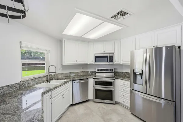 a kitchen with stainless steel appliances a refrigerator sink and stove