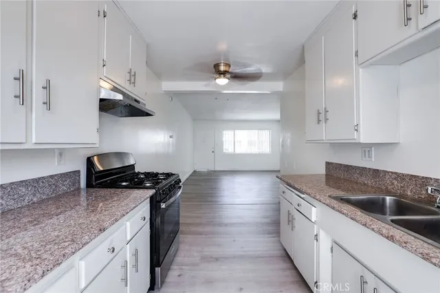 a kitchen with stainless steel appliances granite countertop a sink stove and cabinets